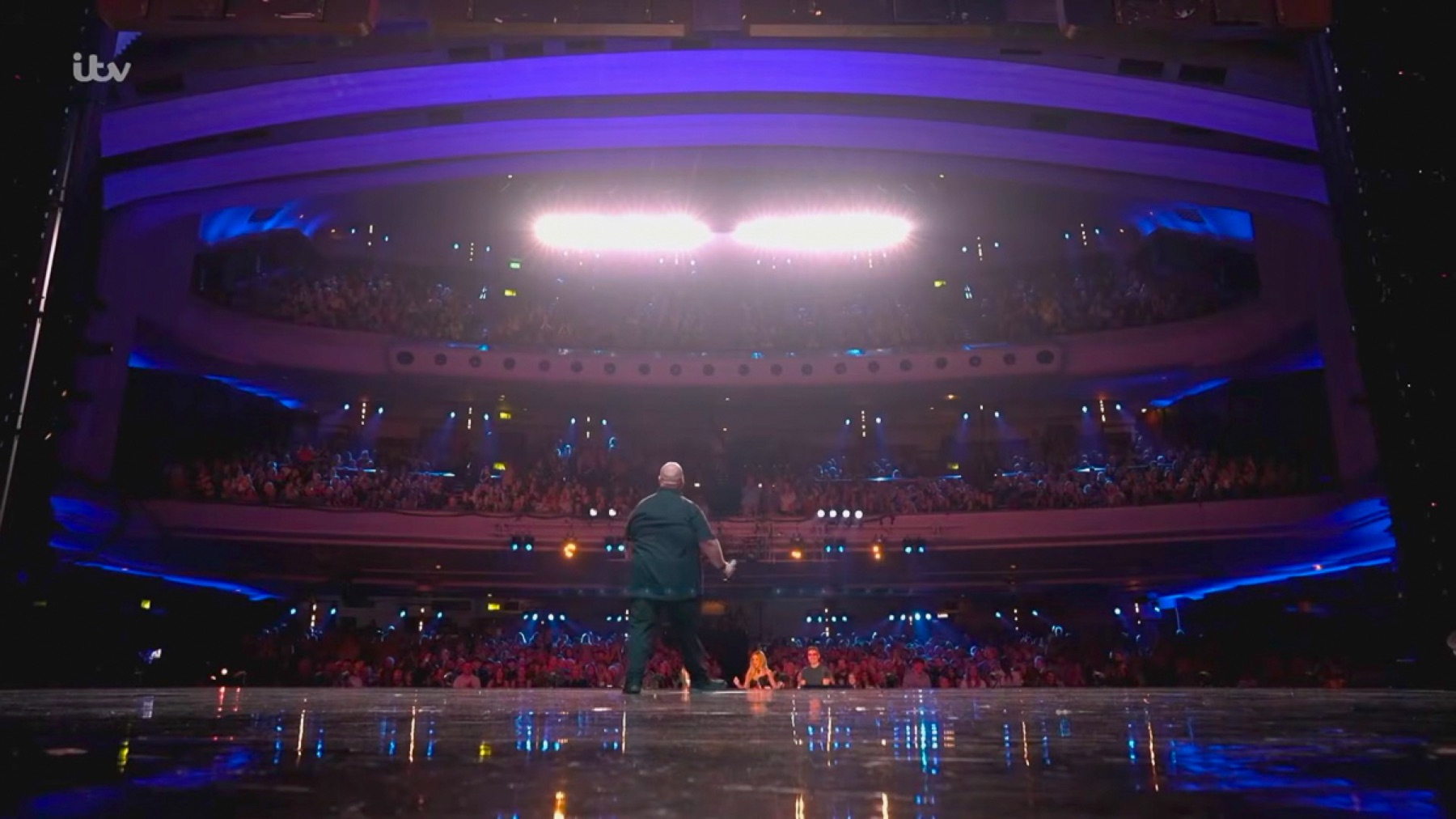 Steven Greenwood standing on the Britain’s Got Talent stage before a packed theatre audience