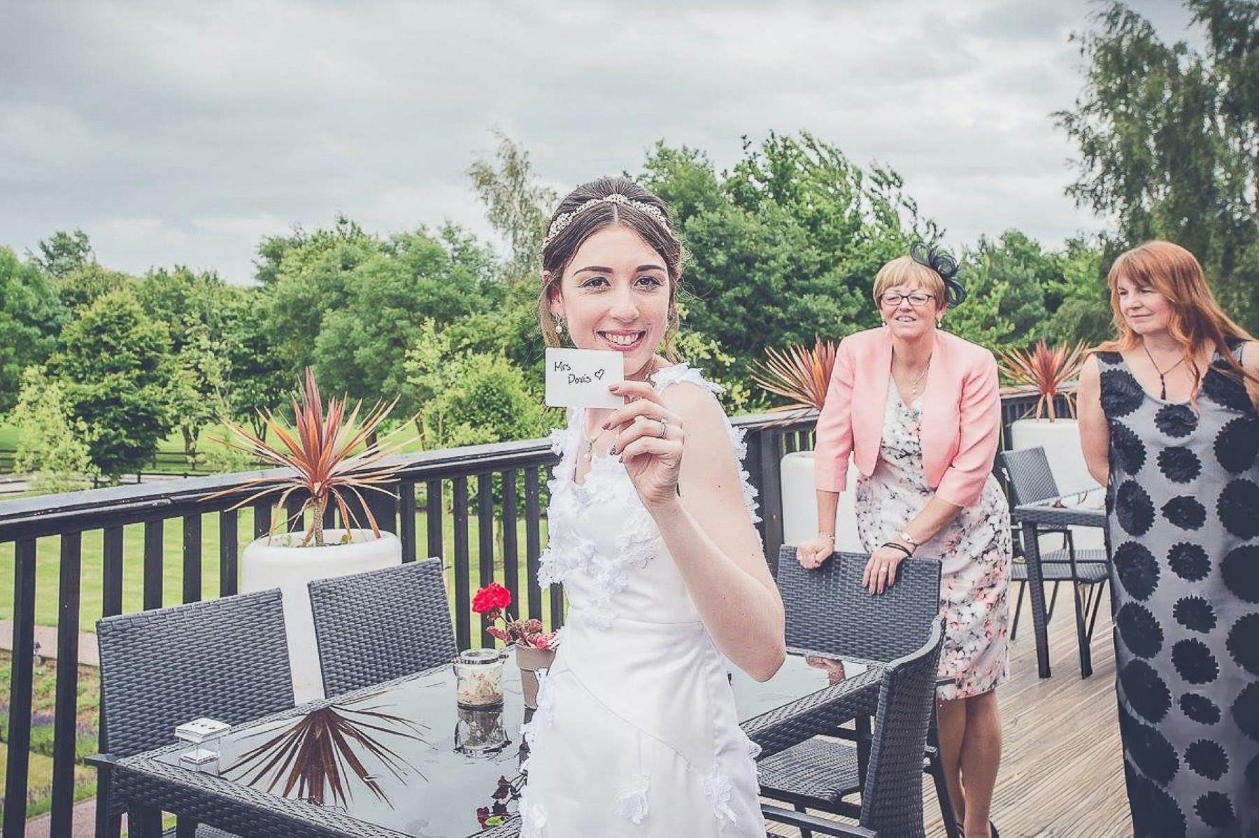 A bride smiling as she reveals a personalised card during close-up magic