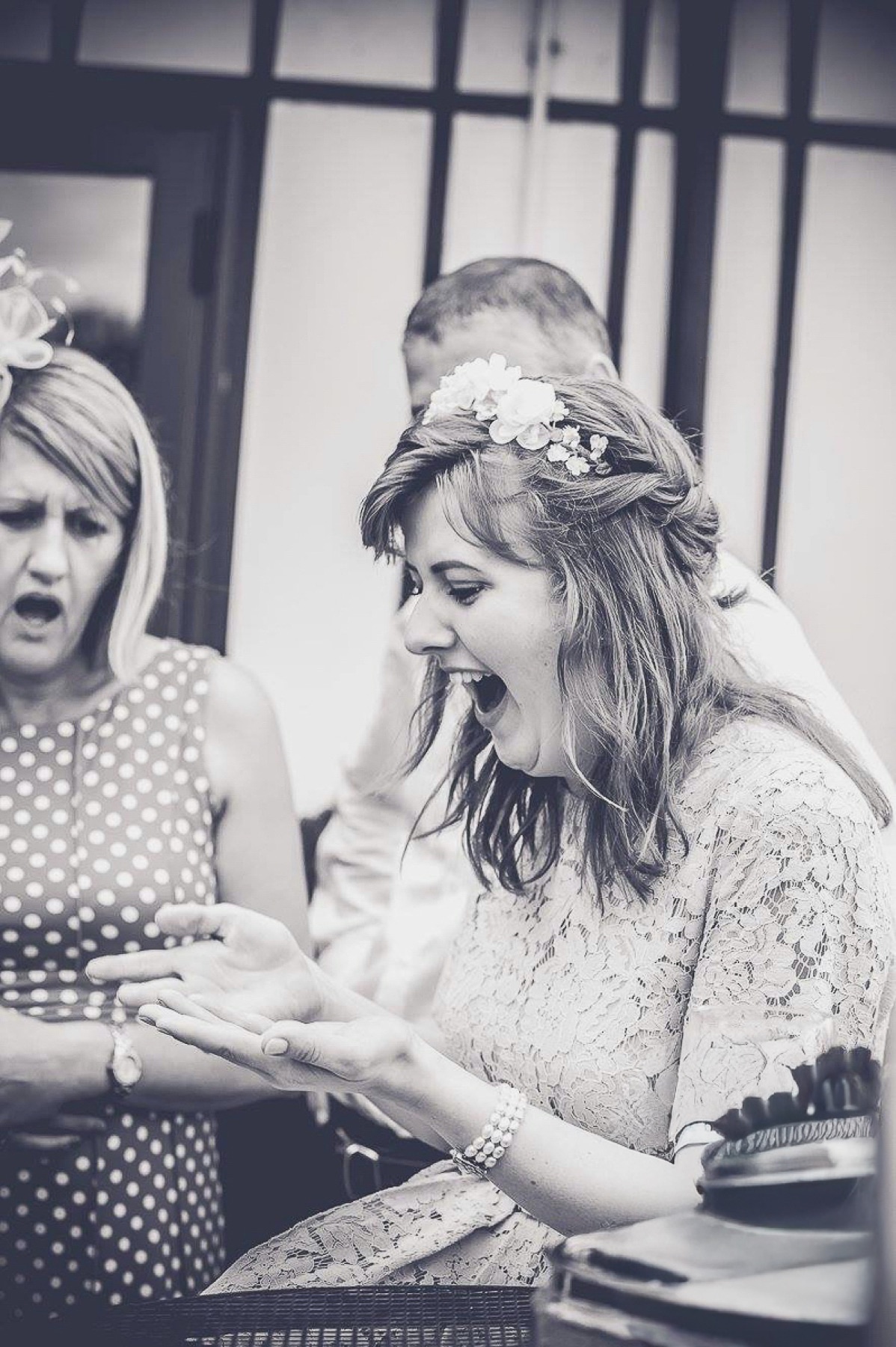 A wedding guest reacting with amazement to magic in her hands